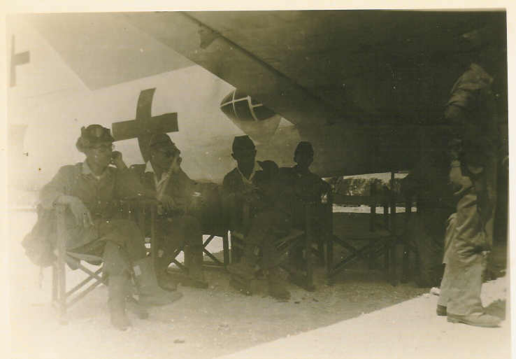 The Japanese Betty Bomber air crew keeps cool under the planes wing.