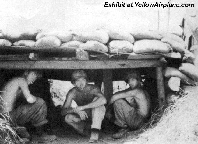 Soldiers sit in a bomb shelter on the island of Ie Shima in WW2.