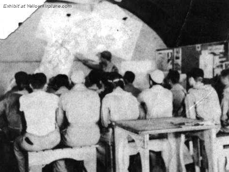 Pilots listen to the Commander in Pre Mission Briefing.