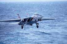an f-14 tomcat landing on the uss kitty hawk aircraft carrier