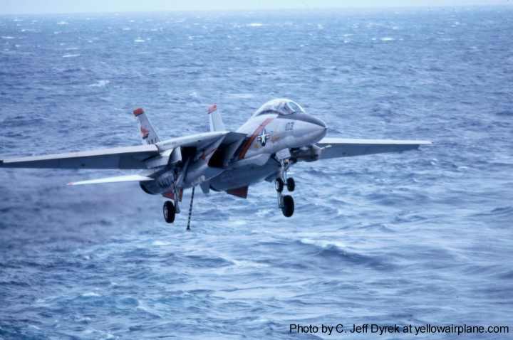 a grumman F-14 tomcat sitting on the catapults of the aircraft carrier, uss kitty hawk