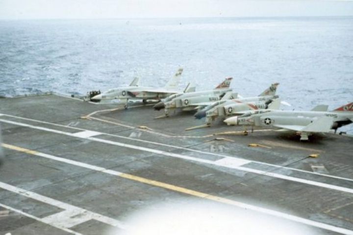 Sitting on the deck of the USS Kitty Hawk are one A-5 Vigilante and three F-4 Phantoms